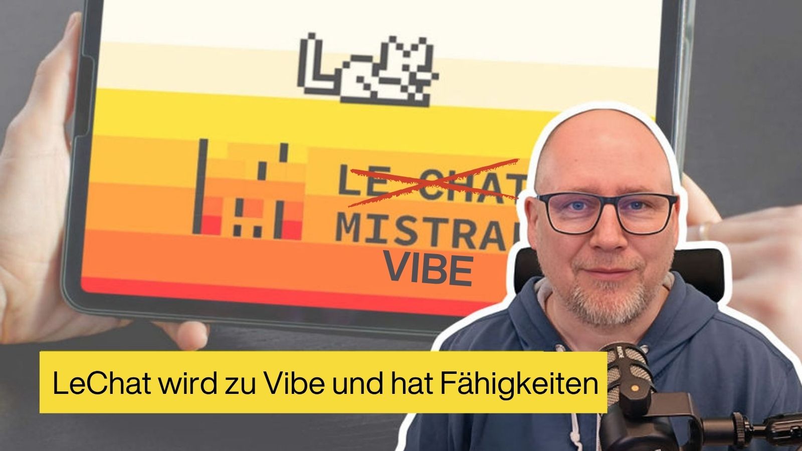 Mann mit Bart und Brille vor einem Monitor, auf dem Mistral steht.